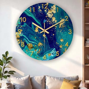 May include: Circular wall clock with a blue, teal, and gold marbled pattern. The clock face has gold numerals and hands. A decorative item for home interiors.