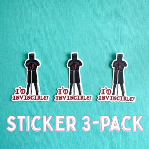 Könnte beinhalten: Ein 3er-Pack Aufkleber mit einem Cartoon-Ritter in schwarzer Rüstung mit einem Schwert. Der Ritter hat einen roten Torso und den Text "I'M INVINCIBLE!" in Rot. Die Aufkleber befinden sich auf einem türkisfarbenen Hintergrund.