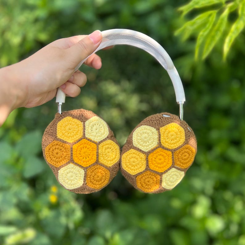 Puede incluir: Auriculares con cubiertas de oreja de ganchillo marr&oacute;n y amarillo con un patr&oacute;n de panal. Los auriculares tienen una diadema y auriculares blancos. Las cubiertas de las orejas est&aacute;n hechas de varios tonos de hilo amarillo y marr&oacute;n.