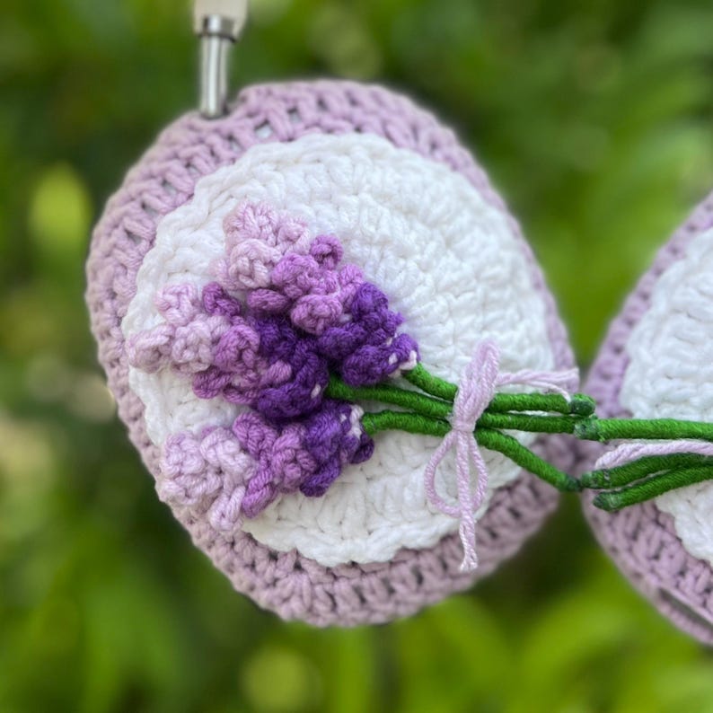 May include: Crocheted lavender-themed coaster with a white center, surrounded by a light purple border. The coaster features a 3D lavender bouquet tied with a light purple ribbon. The green stems and purple flowers add a natural touch.