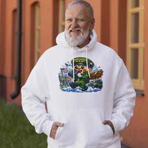 May include: White hooded sweatshirt with a cartoon graphic of a Border Patrol agent. The graphic includes an American flag, a stop sign, and the words "BORDER PATROL" on the agent's hat. The agent is depicted with wings and is wearing a green uniform.