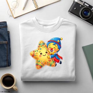 K&ouml;nnte beinhalten: Ein wei&szlig;es Sweatshirt mit Rundhalsausschnitt und einer bunten Grafik eines l&auml;chelnden gelben Sterns, der von einer kleinen Clownfigur mit blauem Hut, rotem Hemd und gelber Fliege umarmt wird, wobei der Stern mit Konfetti verziert ist.