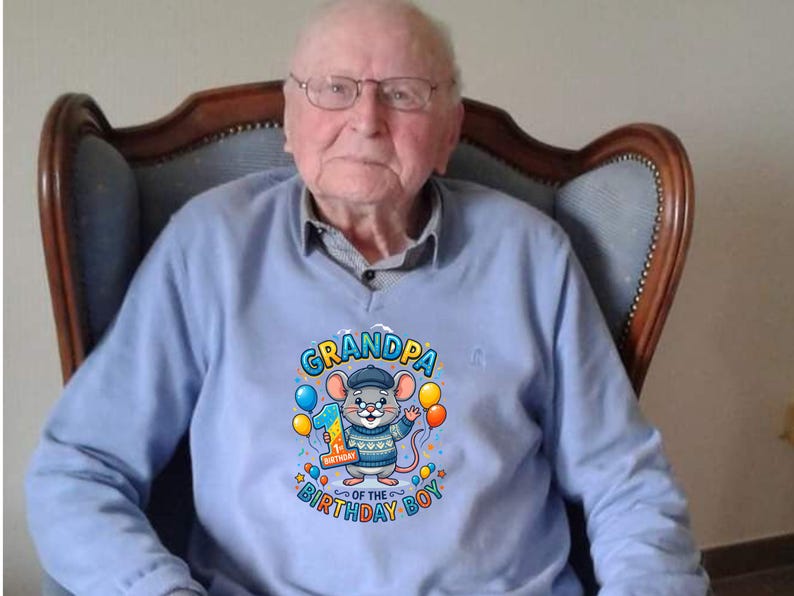 May include: A light blue sweatshirt with a graphic of a cartoon mouse wearing a hat and holding balloons. The text on the shirt reads "Grandpa of the Birthday Boy" with the number "1" on a balloon.