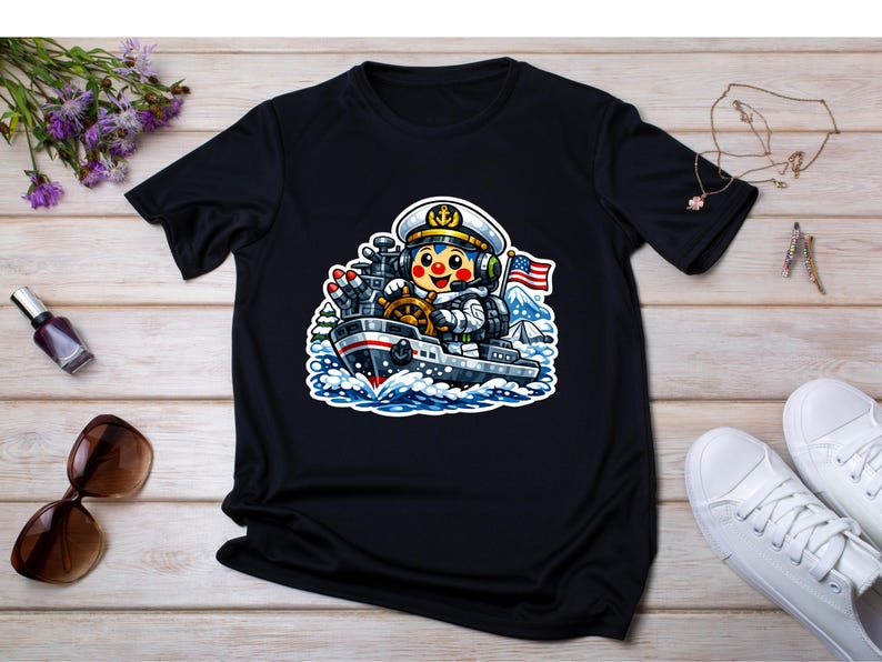 May include: Black t-shirt with a cartoon astronaut captaining a ship. The astronaut wears a white hat and uniform, with an American flag in the background. The ship is grey and red, sailing on blue waves.