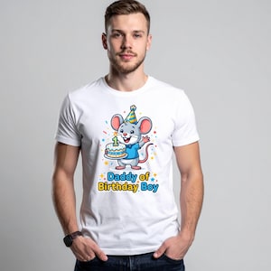 May include: White t-shirt featuring a cartoon mouse wearing a party hat and holding a birthday cake with a number one candle. The text "Daddy of Birthday Boy" is printed below the mouse in blue and yellow.