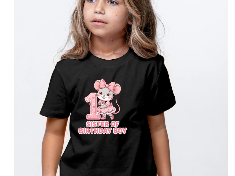 May include: Black t-shirt featuring a pink graphic of a mouse with a bow, the number 1, and the text "SISTER OF BIRTHDAY BOY". The design is in a cartoon style, suitable for a child's birthday celebration.