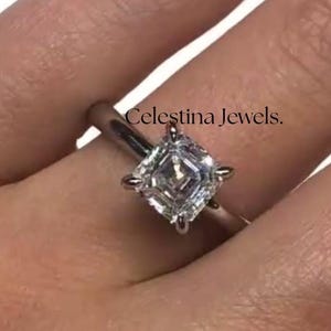 May include: A silver ring with a square-cut diamond. The ring is set on a woman's hand. The text "Celestina Jewels" is visible on the image.