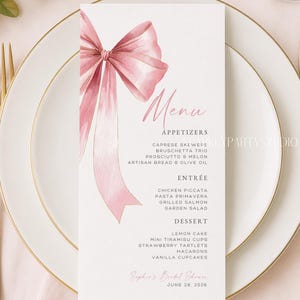 Könnte beinhalten: Eine Menükarte mit einem rosa Aquarell-Schleifendesign. Die Speisekarte listet Vorspeisen, Hauptgerichte und Desserts für eine Brautparty auf. Der Text enthält das Datum, den 28. Juni 2026, und den Namen "Sophie's Bridal Shower."