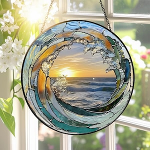 May include: A circular stained glass window showing a wave design with a sunset scene. The wave is crafted from blue, green, and amber glass. The sunset displays a bright yellow sun over the sea. The window is suspended by a chain.