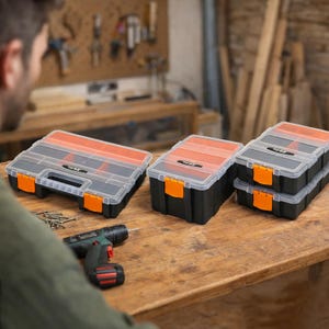 Pode incluir: Caixas organizadoras de plástico preto e laranja com tampas transparentes. Em uma superfície de madeira, há uma furadeira sem fio e parafusos. As caixas têm fechos laranja.