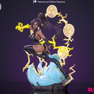 Puede incluir: Una figura de anime negra y morada de una mujer con cabello negro largo y un atuendo negro. Ella sostiene un rayo amarillo en su mano derecha y está de pie sobre una base azul y blanca. El fondo es morado. El texto "BLEACH" es visible en la esquina inferior derecha de la imagen.