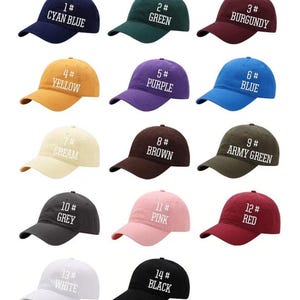 Puede incluir: Una colecci&oacute;n de gorras de b&eacute;isbol en varios colores: azul cian, verde, burdeos, amarillo, morado, azul, crema, marr&oacute;n, verde militar, gris, rosa, rojo, blanco y negro. Cada gorra est&aacute; etiquetada con un n&uacute;mero y el nombre del color.