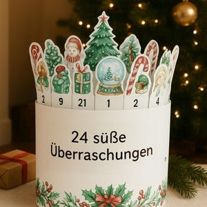 May include: A white Christmas advent calendar with 24 numbered cutouts featuring festive illustrations. The calendar has a holly and berry design at the base and the text "24 s&uuml;&szlig;e &Uuml;berraschungen". A small gift box is visible in the background.