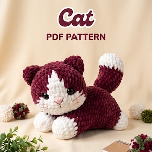 Peut inclure: Un jouet chat en peluche fait de fil bordeaux foncé et blanc avec une texture douce. Le chat a des yeux noirs, un nez cousu rose et une tache blanche sur le visage et les pattes. Au-dessus, le texte indique Cat PDF PATTERN en lettres bordeaux.