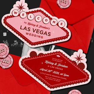 May include: Las Vegas wedding invitations featuring a pink and red design, resembling the iconic Las Vegas sign. The invitations include the names Kelsey & Jordan, wedding details, and casino chip accents. Red envelopes complete the theme.