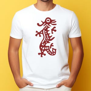 K&ouml;nnte beinhalten: Wei&szlig;es T-Shirt mit einem weinroten Drachendesign. Der Drache ist stilisiert mit detailliertem K&ouml;rper und Kopf und mittig auf dem T-Shirt platziert. Das T-Shirt besteht aus einem weichen Material und ist f&uuml;r den Freizeitgebrauch geeignet.