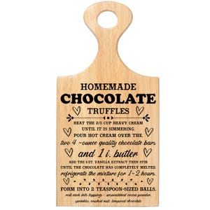 May include: Wooden cutting board with a handle, featuring the text "HOMEMADE CHOCOLATE TRUFFLES" and a recipe. The board includes instructions for making truffles, with measurements in ounces and teaspoons. The board is light brown.