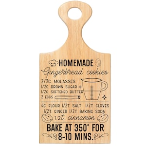 May include: A light-colored wooden cutting board with a handle, featuring a recipe for homemade gingerbread cookies. The recipe includes ingredients like molasses, brown sugar, and flour, with instructions to bake at 350 degrees Fahrenheit for 8-10 minutes.
