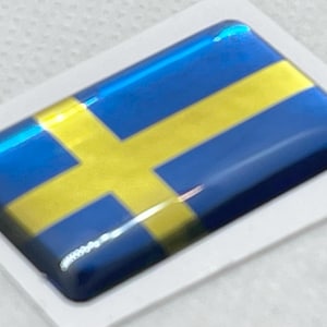 Op de afbeelding: Een blauwe en gele sticker met de Zweedse vlag. De sticker is glanzend en heeft een 3D-effect.