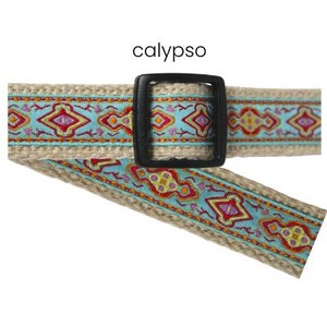 Pode incluir: Um cinto bege com fivela preta e um design estampado em turquesa, vermelho e amarelo. A palavra "calypso" est&aacute; impressa acima do cinto.