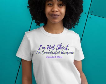 May include: White crew neck t-shirt with the text "I'm Not Short, I'm Concentrated Awesome" in purple and green. The hashtag #popularT-Shirts is below the text. The shirt is a crew neck style.