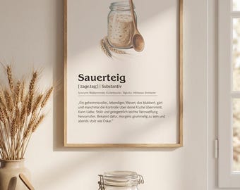 May include: A framed wall art print featuring a dictionary-style definition of Sauerteig, including a watercolor illustration of a glass jar of sourdough starter with a wooden spoon and wheat stalks, set against a light cream background.