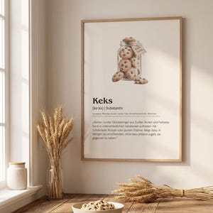 Könnte beinhalten: Ein gerahmter Kunstdruck mit einer wörterbuchartigen Definition des Wortes Keks. Das Bild zeigt ein Glas mit Schokoladenkeksen, begleitet von Text, der das Substantiv, Synonyme und einen beschreibenden Absatz in deutscher Sprache darstellt.