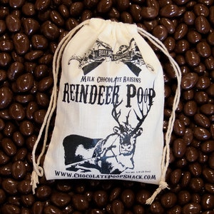 May include: A white drawstring bag filled with milk chocolate raisins. The bag has a reindeer illustration and the text "BILLY MO'S CHOCOLATE MILK CHOCOLATE RAISINS REINDEER POOP Net Wt. 1/4 LB (60z) WWW.CHOCOLATEPOOPSHACK.COM".