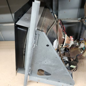 May include: A disassembled vintage television screen with a black and silver metal frame. The screen is visible and the back of the television is exposed, showing wires and components.