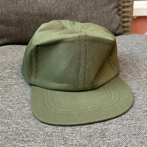 Peut inclure: Casquette de baseball vert olive avec une visière plate. La casquette a une couronne structurée et est fabriquée dans un tissu résistant. La visière est incurvée et cousue. Un accessoire classique et décontracté.