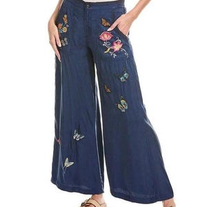 May include: Navy blue wide-leg trousers adorned with embroidered butterflies and floral patterns. The trousers have a button and zip fastening, pockets, and a loose fit. The embroidery incorporates multiple colours, enhancing the garment's decorative appeal.