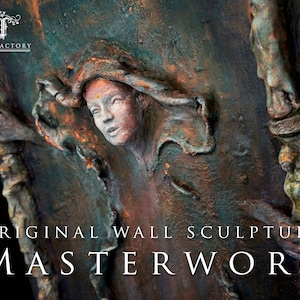 May include: Original wall sculpture artwork featuring a woman's face with a copper and green patina finish. The sculpture is titled "MASTERWORK" and is signed "FAE FACTORY".