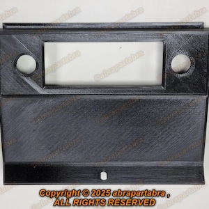 Op de afbeelding: Zwarte kunststof radiotrimkit met twee ronde openingen. Copyright © 2025 abrapartabra, ALL RIGHTS RESERVED.