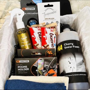May include: A gift box containing a Carstore air freshener, a bottle of One Billion fragrance spray, two Kinder Bueno White chocolate bars, a Carstore air vent phone holder, a bottle of MA Cherry Snow Foam, and two folded cleaning cloths.