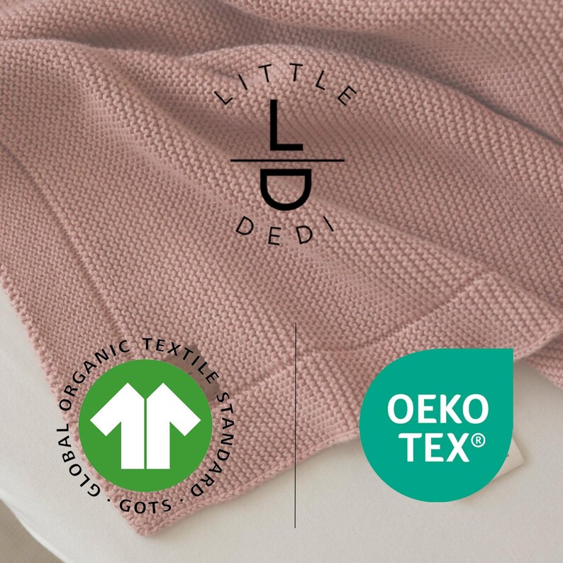 Może przedstawiać: R&oacute;żowa dzianinowa kołdra o teksturowanej powierzchni. Kołdra ma obramowanie i zawiera napis "LITTLE DEDI" oraz logo GOTS i OEKO-TEX.