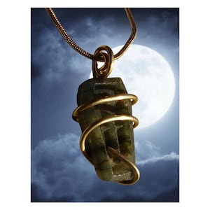 May include: A green stone pendant wrapped in gold wire, hanging from a gold chain against a backdrop of a cloudy night sky and a full moon.