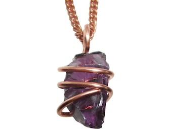 May include: A raw, purple amethyst pendant wrapped in copper wire, suspended from a copper chain. The amethyst has a rough, natural texture, and the wire is coiled around the stone. The chain is a twisted rope design.