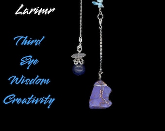 Könnte beinhalten: Zwei silberne Kettenanhänger mit blauen und violetten Edelsteinen. Ein Anhänger hat einen dunkelblauen Stein mit einem klaren Kristall, der andere einen violetten Stein. Der Text links lautet "Lapis Lazuli Larimr Third Eye Wisdom Creativity."