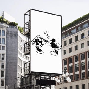 Pode incluir: Um grande outdoor ao ar livre com uma ilustra&ccedil;&atilde;o em preto e branco de Mickey e Minnie Mouse se beijando, com tr&ecirc;s cora&ccedil;&otilde;es acima deles. A imagem &eacute; definida em um cen&aacute;rio de edif&iacute;cios urbanos e um c&eacute;u brilhante.