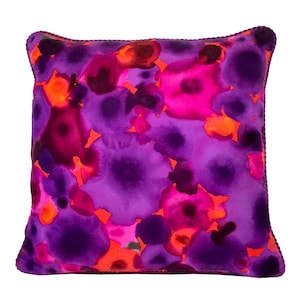 May include: Purple and pink throw pillow with a watercolor-style design of abstract shapes.