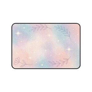 May include: Rectangular mousepad with a pastel watercolor design. The background features a blend of pink, blue, and yellow hues, with scattered star accents. Delicate floral and leaf outlines frame the edges, creating a whimsical aesthetic.