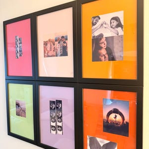 May include: A series of framed photographs in black frames, displayed on a wall. The frames feature photos with coloured mounts, including pink, orange, green, and purple. The photos depict people and include film strip style photos.