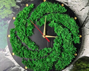 May include: Round black wall clock with a vibrant green moss design. The clock features gold-colored hour markers and hands, with a red second hand. The clock's design incorporates natural elements, creating a unique decorative piece.