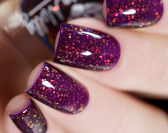 Nail polish - "The Least I Could Do" A dark purple base with orange to green iridescent glitters.