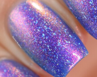 Nail polish - "Here We Go Again" A bright blue with pink aurora shimmer and holographic flakes.