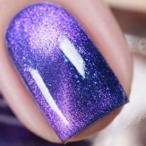 Magnetic nail polish - Behind It All - A blue nail polish blue micro flakes and a purple / pink / gold shifting magnetic effect.