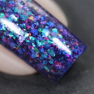 Nail polish - Card Trick - A dark blue / purple nail polish filled with different coloured iridescent flakes.