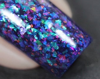 Nail polish - Card Trick - A dark blue / purple nail polish filled with different coloured iridescent flakes.
