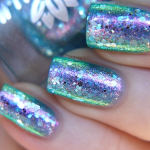 Nail polish - "Turning Tides" A pale aqua blue jelly base with pink / green / blue aurora shimmer and silver glitters