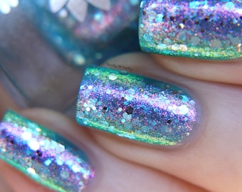 Nail polish - "Turning Tides" A pale aqua blue jelly base with pink / green / blue aurora shimmer and silver glitters